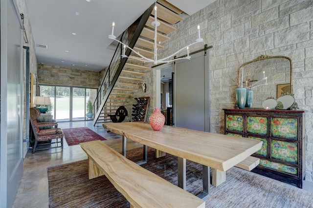 interior space featuring concrete flooring, a towering ceiling, and a barn door