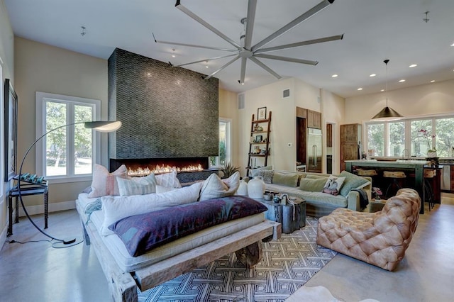 living room with ceiling fan and a large fireplace