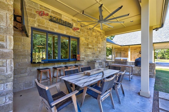 view of patio with an outdoor kitchen, ceiling fan, and a grill