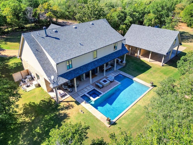 view of pool with an in ground hot tub, a yard, a patio, and an outdoor living space