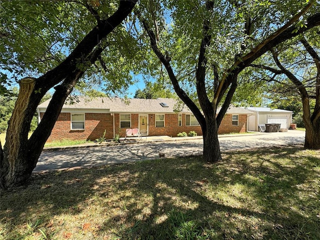 single story home featuring a front lawn and a garage