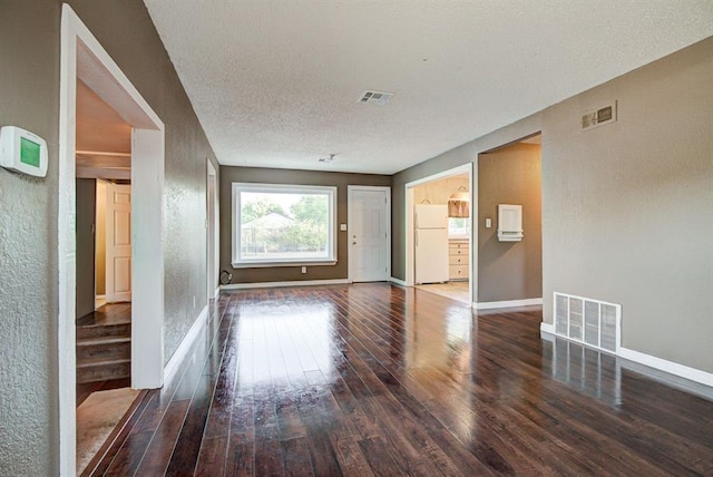 unfurnished living room featuring hardwood / wood-style floors and a textured ceiling