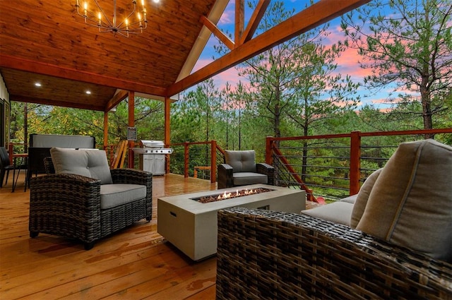 deck at dusk featuring a grill and a fire pit