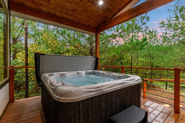 deck at dusk featuring a hot tub