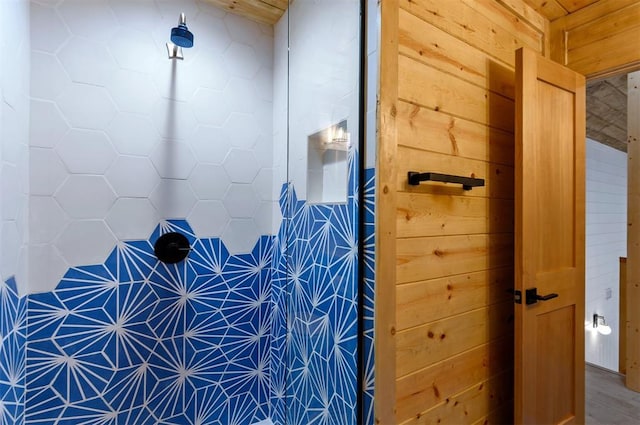 bathroom with wood-type flooring, walk in shower, and wooden walls