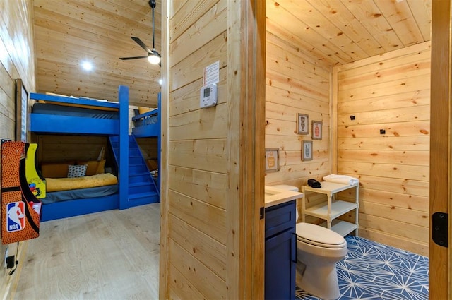 bathroom with wooden ceiling, wood walls, hardwood / wood-style floors, toilet, and vanity