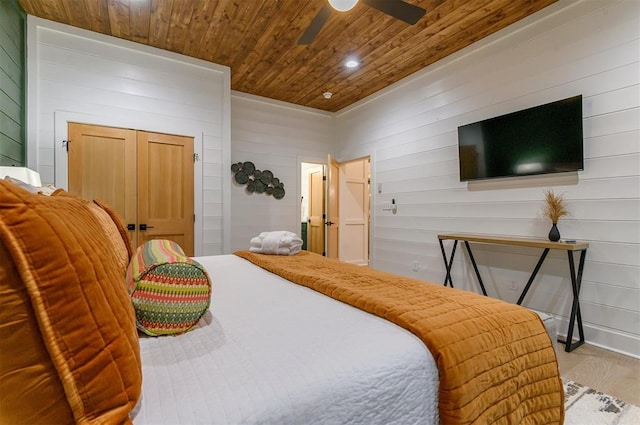 bedroom featuring ceiling fan, wood walls, light wood-type flooring, and wood ceiling