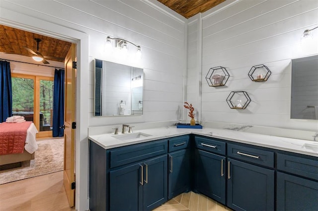 bathroom featuring wooden walls, hardwood / wood-style floors, vanity, and wood ceiling