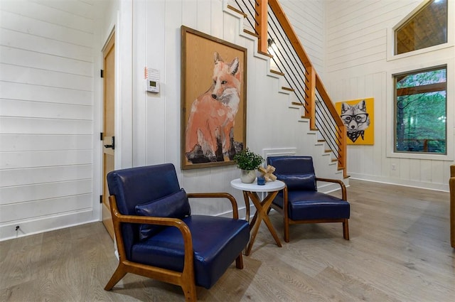 living area with hardwood / wood-style floors and wood walls