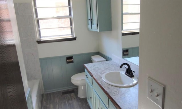 bathroom featuring a wealth of natural light, vanity, wood-type flooring, and toilet