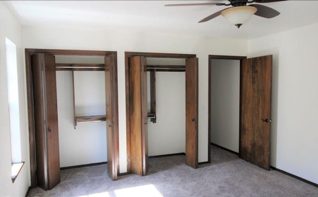 unfurnished bedroom with multiple closets, ceiling fan, and carpet floors