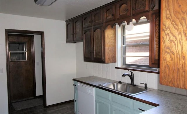 kitchen featuring dishwasher, sink, dark wood-type flooring, tasteful backsplash, and dark brown cabinets