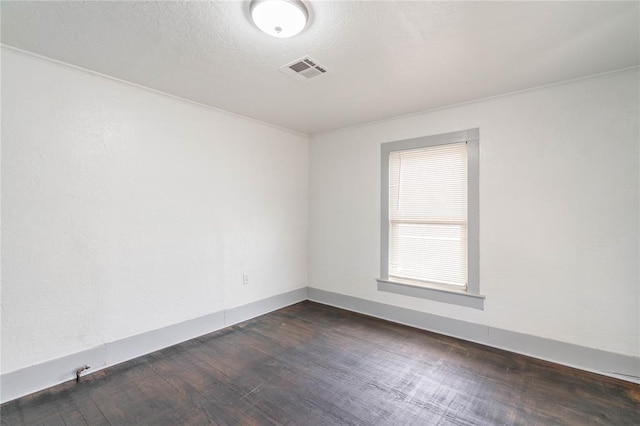 empty room with crown molding and dark wood-type flooring