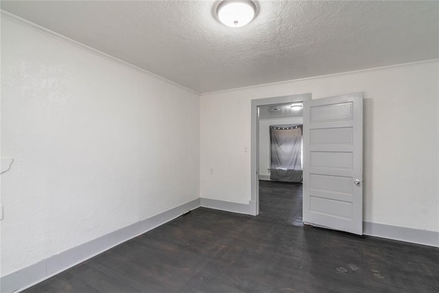 spare room featuring a textured ceiling, dark hardwood / wood-style floors, and ornamental molding