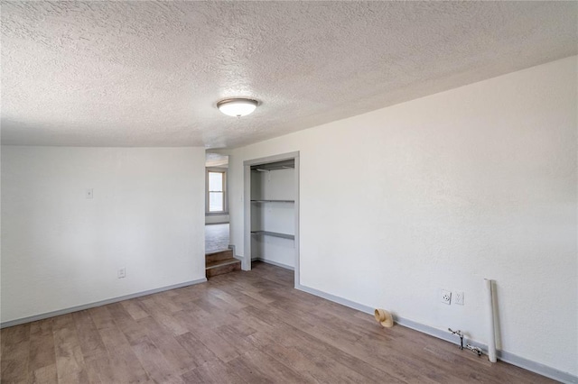 unfurnished bedroom featuring hardwood / wood-style floors and a textured ceiling