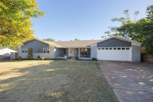 ranch-style home featuring covered porch, a garage, and a front yard