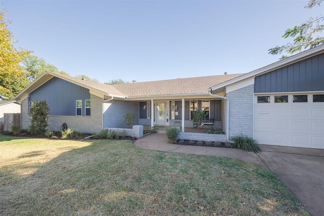 ranch-style house featuring covered porch, a front yard, and a garage