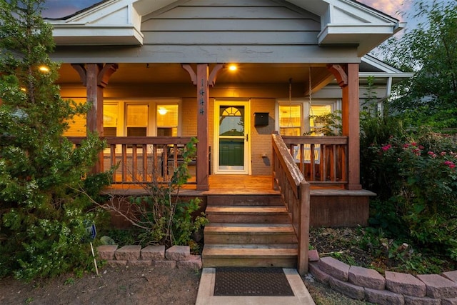 exterior entry at dusk featuring covered porch