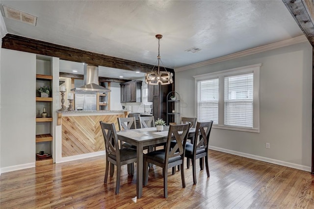 dining room with wood-type flooring and ornamental molding