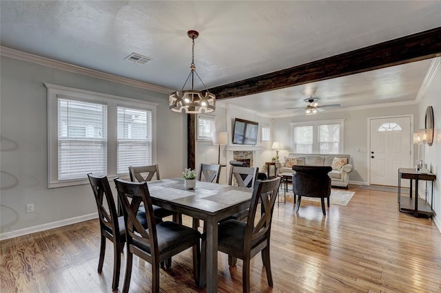 dining space featuring ceiling fan with notable chandelier, light wood-type flooring, and crown molding