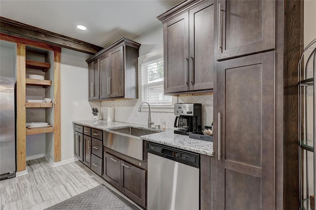 kitchen with sink, stainless steel dishwasher, decorative backsplash, light stone countertops, and dark brown cabinetry