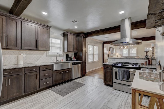 kitchen with stainless steel appliances, dark brown cabinetry, beamed ceiling, and extractor fan