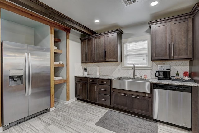 kitchen featuring dark brown cabinetry, light stone countertops, sink, backsplash, and appliances with stainless steel finishes