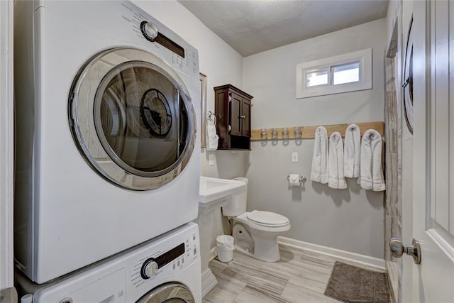 bathroom with stacked washer and dryer and toilet