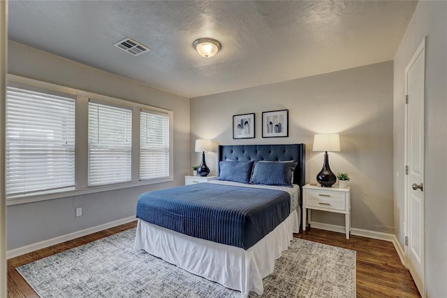 bedroom featuring a textured ceiling and dark hardwood / wood-style floors