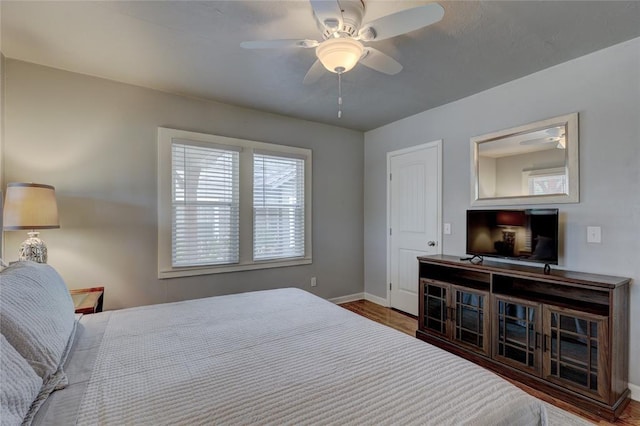 bedroom with dark hardwood / wood-style floors and ceiling fan