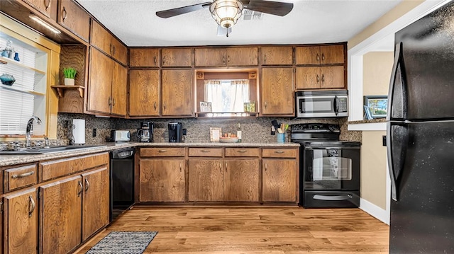 kitchen with decorative backsplash, light hardwood / wood-style floors, and black appliances