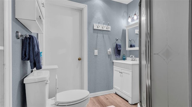 bathroom featuring vanity, wood-type flooring, and toilet