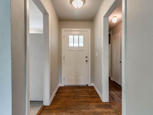 doorway to outside with crown molding and dark hardwood / wood-style flooring