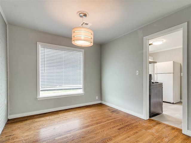 spare room featuring light hardwood / wood-style flooring and ornamental molding