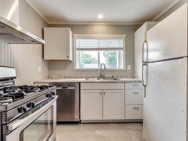 kitchen featuring white cabinetry, sink, stainless steel appliances, wall chimney range hood, and light stone counters