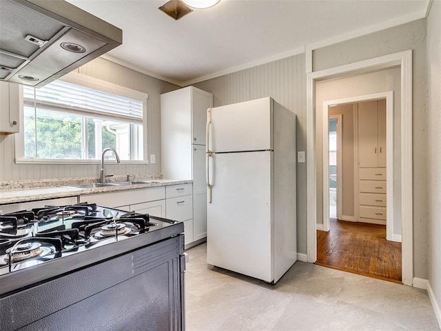 kitchen with white refrigerator, sink, light hardwood / wood-style flooring, range hood, and white cabinetry