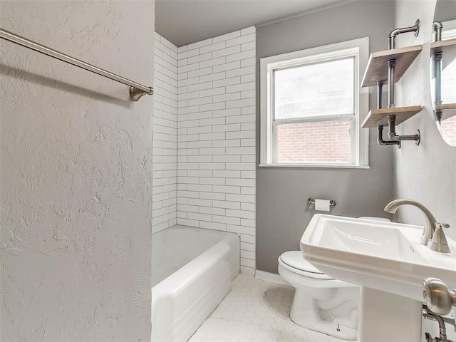 full bathroom featuring toilet, tiled shower / bath combo, tile patterned floors, and sink