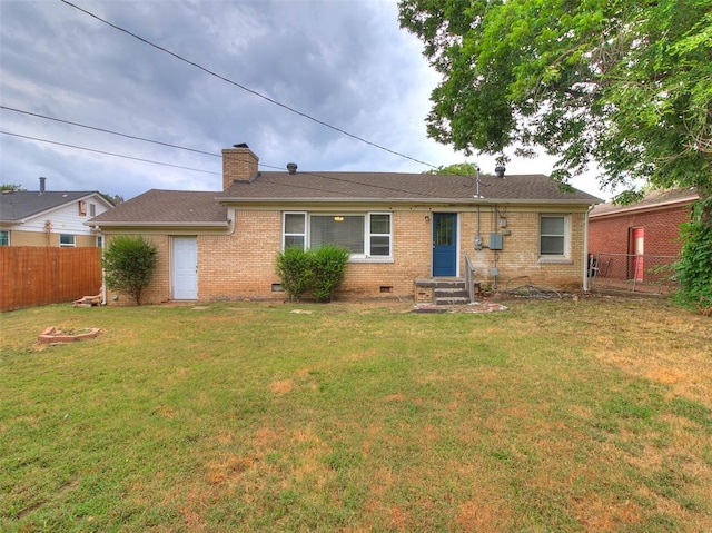 rear view of property featuring a lawn