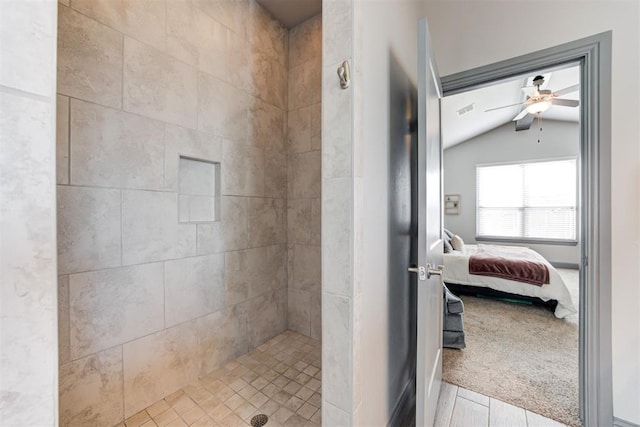 bathroom with a tile shower, ceiling fan, lofted ceiling, and hardwood / wood-style floors