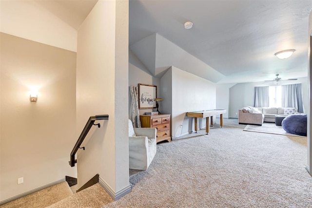 interior space featuring ceiling fan, light colored carpet, and vaulted ceiling