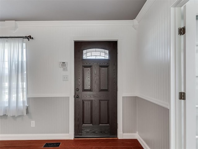 entryway featuring a wealth of natural light, dark wood-type flooring, and ornamental molding