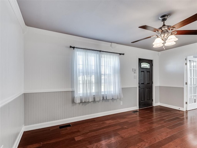 foyer entrance with ceiling fan, dark wood-type flooring, and ornamental molding