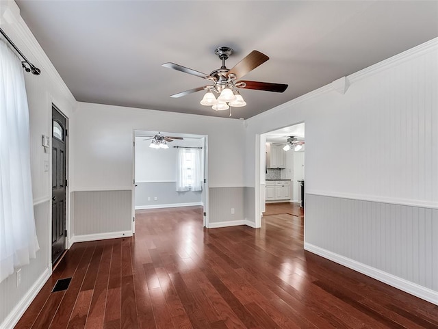 unfurnished room with crown molding, ceiling fan, and dark wood-type flooring