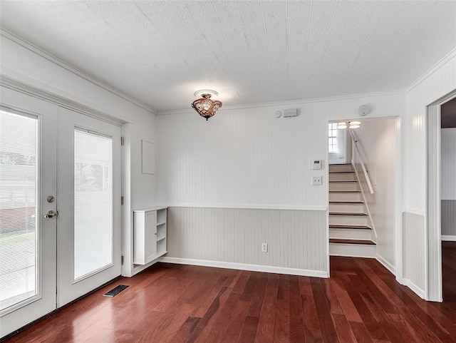 empty room with french doors, dark hardwood / wood-style flooring, ornamental molding, and a healthy amount of sunlight