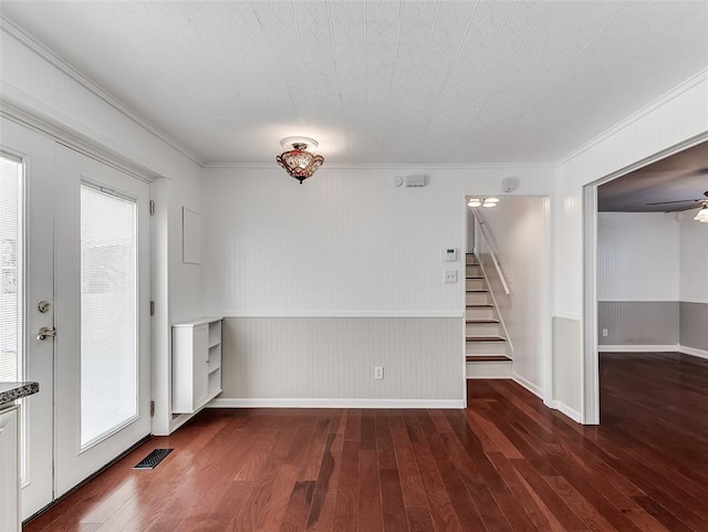 empty room featuring crown molding, dark hardwood / wood-style flooring, and plenty of natural light