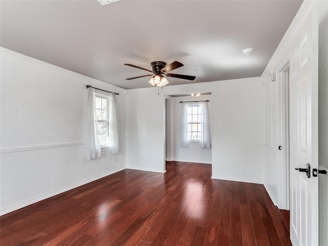 unfurnished room with ceiling fan, ornamental molding, and dark wood-type flooring