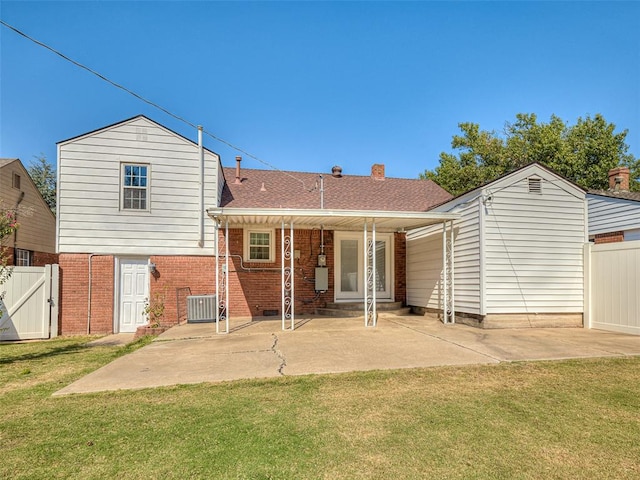 rear view of property with central air condition unit, a patio area, and a yard