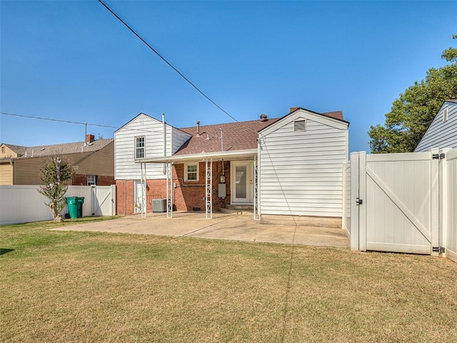 rear view of property featuring cooling unit, a patio area, and a lawn