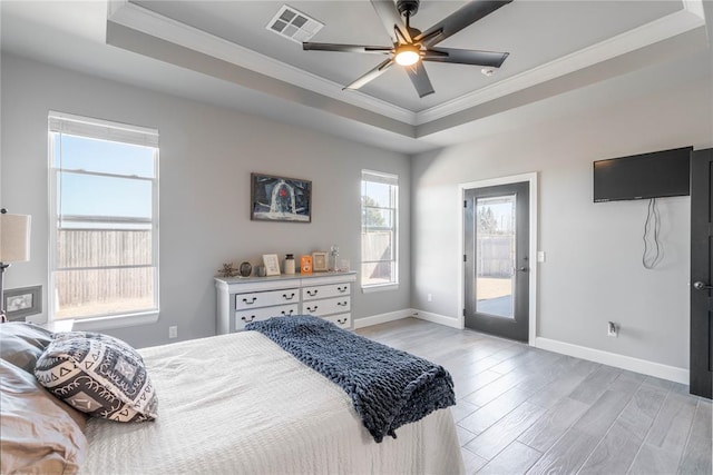 bedroom with ceiling fan, a raised ceiling, light wood-type flooring, and access to outside