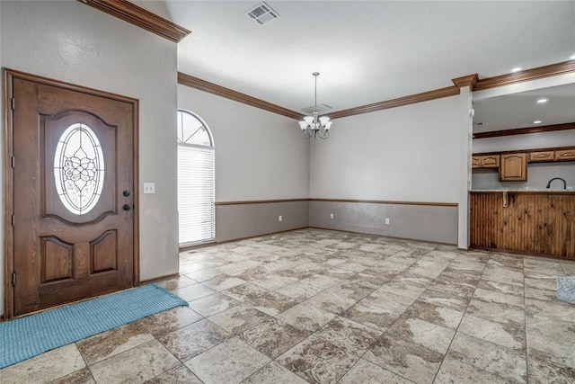 foyer featuring an inviting chandelier, ornamental molding, and sink